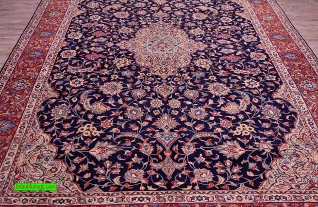 Hand knotted floral Persian Sarouk rug with navy blue filed and red border