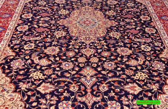 Hand knotted floral Persian Sarouk rug with navy blue filed and red border