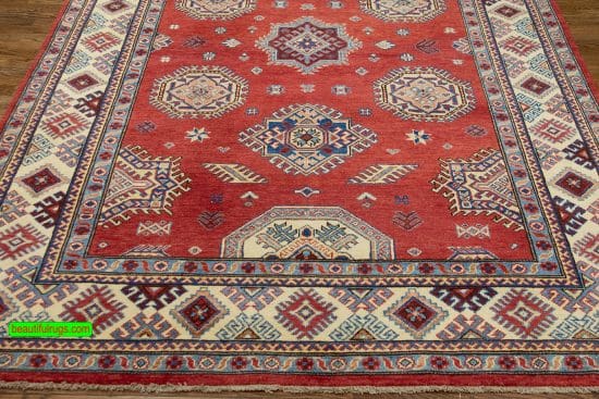 Handmade geometric Kazak style rug in red color. Size 6x9.4.