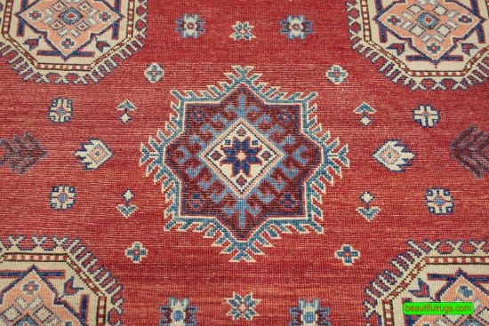 Handmade geometric Kazak style rug in red color. Size 6x9.4.