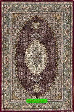 Traditional Persian Tabriz rug in raspberry red color made of wool and silk. Size 3.4x5.