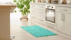 kitchen in white color and bleached oak hardwood floor and turquoise throw rug