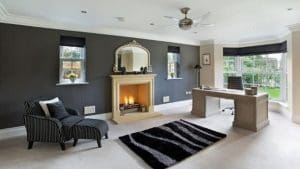 living room with fireplace and mirror, dark gray wall paint and black rug