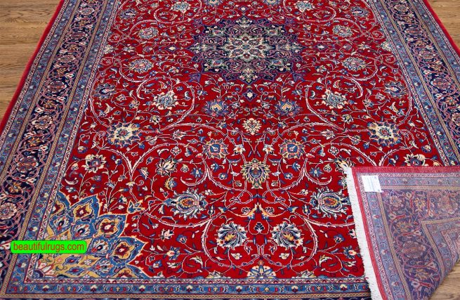 Hand knotted Persian Sarouk area rug with red and navy blue made of wool. Size 7.1x10.4.