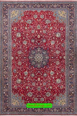 Hand knotted Persian Sarouk area rug with red and navy blue made of wool. Size 7.1x10.4.