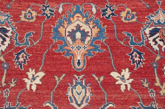 A floral-geometric handmade wool Kazak style rug in red and beige colors. Size 6x9.