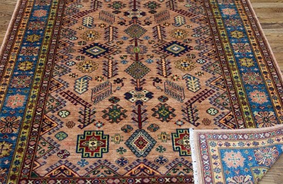 Handmade oriental rug in geometric Kazak style in brown and blue color. Size 5.1x7.