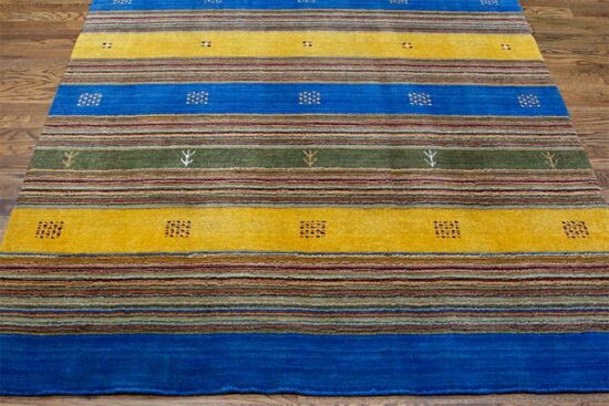 A colorful 5x8 rug in contemporary style made of wool and decorated with blue and mustard colors.