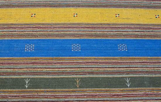 A colorful 5x8 rug in contemporary style made of wool and decorated with blue and mustard colors.