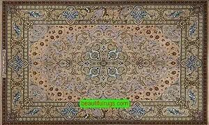 A handmade Persian Isfahan silk rug with blue, brown, gold, earth tone colors. A handmade Persian Isfahan silk rug with blue, brown, gold, earth tone colors.