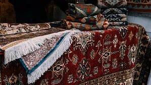 A red rug and kilim rugs are placed on a bench. A red rug and kilim rugs are placed on a bench.