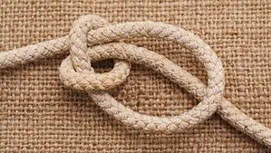 Image of a knitted fiber place on an earth tone and flat weave rug.