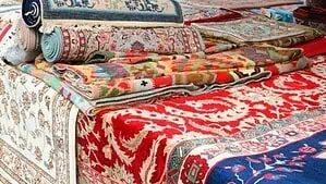 Several rugs in many colors rolled and laid on a bench. Several rugs in many colors rolled and laid on a bench.
