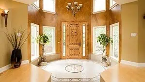 A large octagonal entryway with a high ceiling and an octagonal rug on the floor A large octagonal entryway with a high ceiling and an octagonal rug on the floor