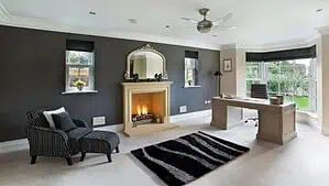 living room with fireplace and mirror, dark gray wall paint and black rug living room with fireplace and mirror, dark gray wall paint and black rug