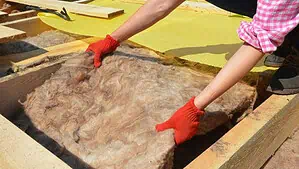Image of two hands placing wool inside a square wooden place