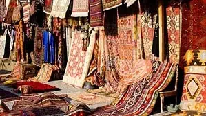 A rug Bazar with many colorful tribal pattern rugs. A rug Bazar with many colorful tribal pattern rugs.