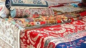 A variety of rug styles individually rolled and placed on a bench A variety of rug styles individually rolled and placed on a bench