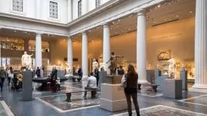 Image of Metropolitan Museum of Art in New York. Visitors are admiring statues.